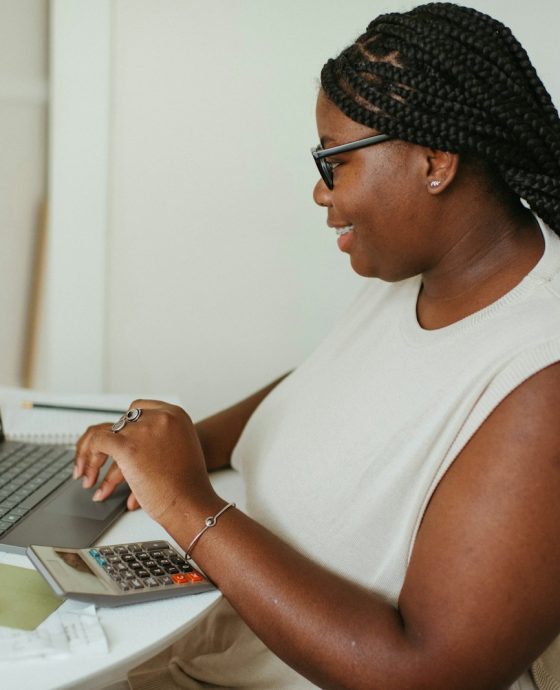 a person sitting at a table using a laptop computer